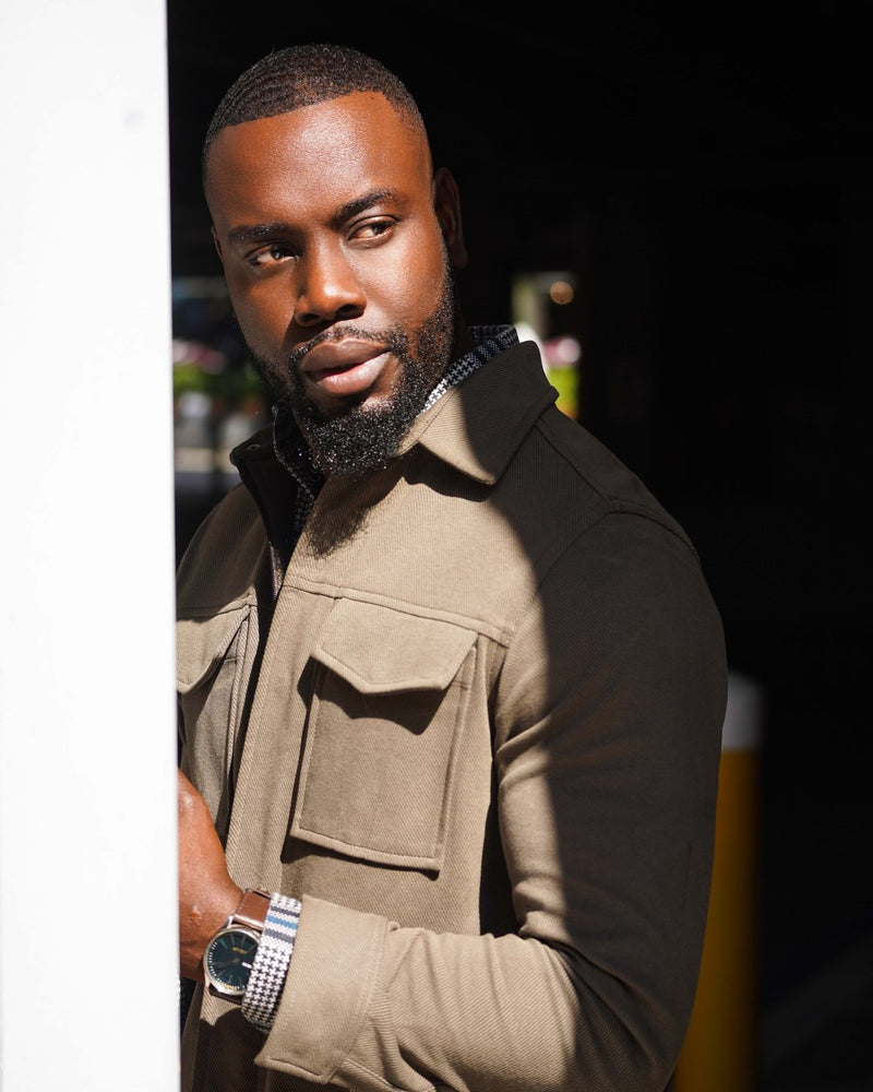 Man in an olive twill shirt jacket in the sunlight